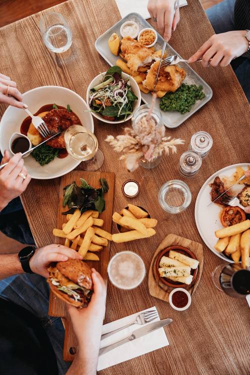 A full table of pub classic dishes: fish and chips, pie and mash, burger and chips
